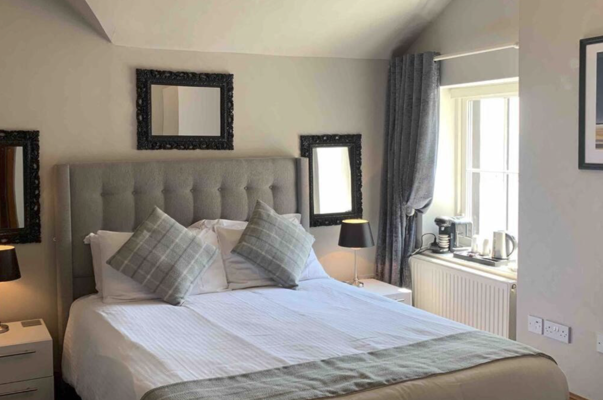 A bright double bedroom at Chandlers Apartment with a window overlooking the gardens
