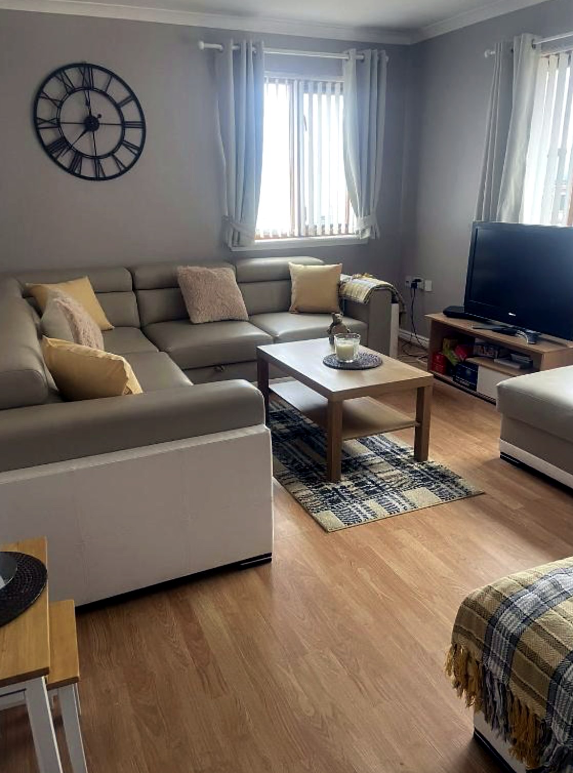 Living and dining area at Fraoch with corner sofa, television and two windows