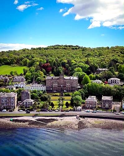 Aerial view of a stone mansion and its lawns above the shore road at Rothesay, Isle of Bute