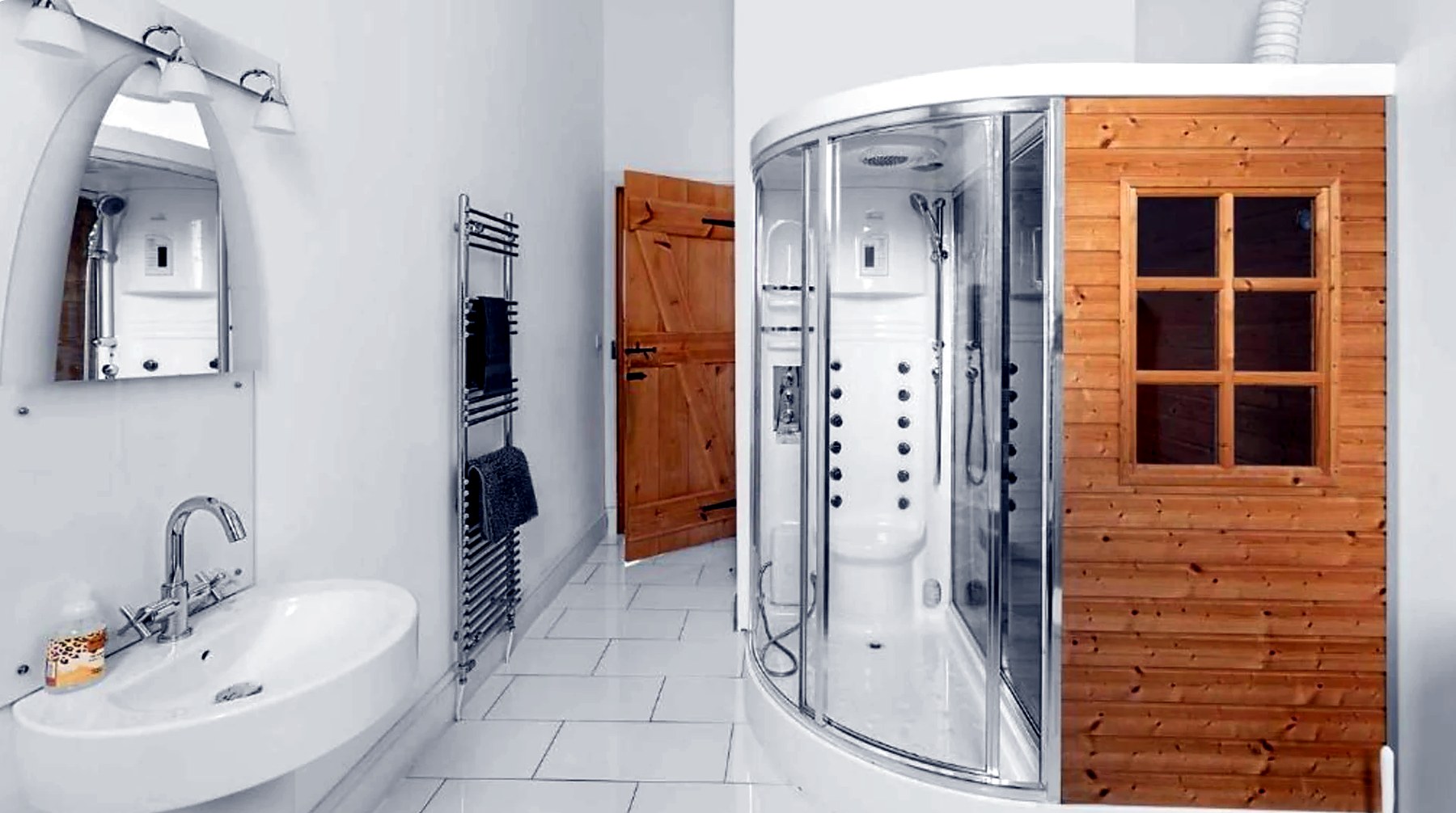 White tiled shower room with steam cabin and heated towel rail