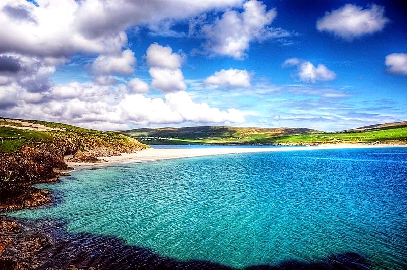 The turquoise water and white sand beach of St Ninian's Bay on the Isle of Bute under a bright summer sky