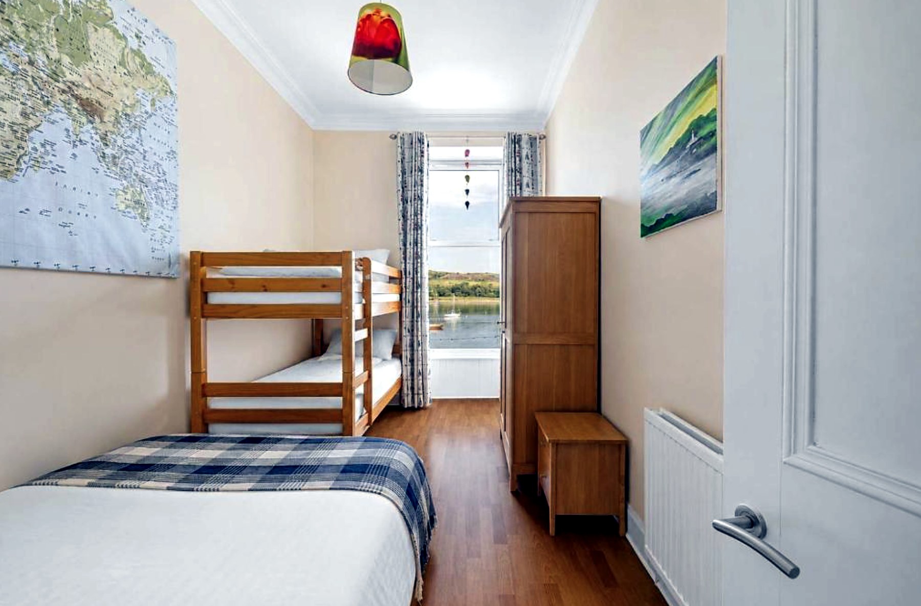 Bunk room at Above the Bay with a single bed, bunks and a window looking out to yachts on Kames Bay