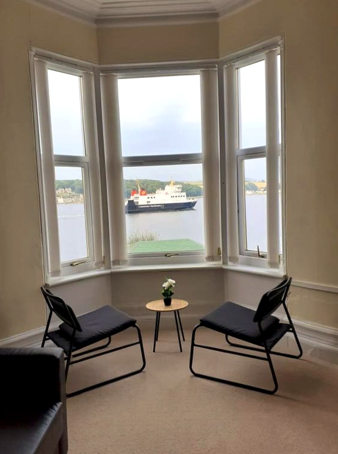 Bay window at Commodore Guest House with the CalMac ferry crossing Rothesay Bay