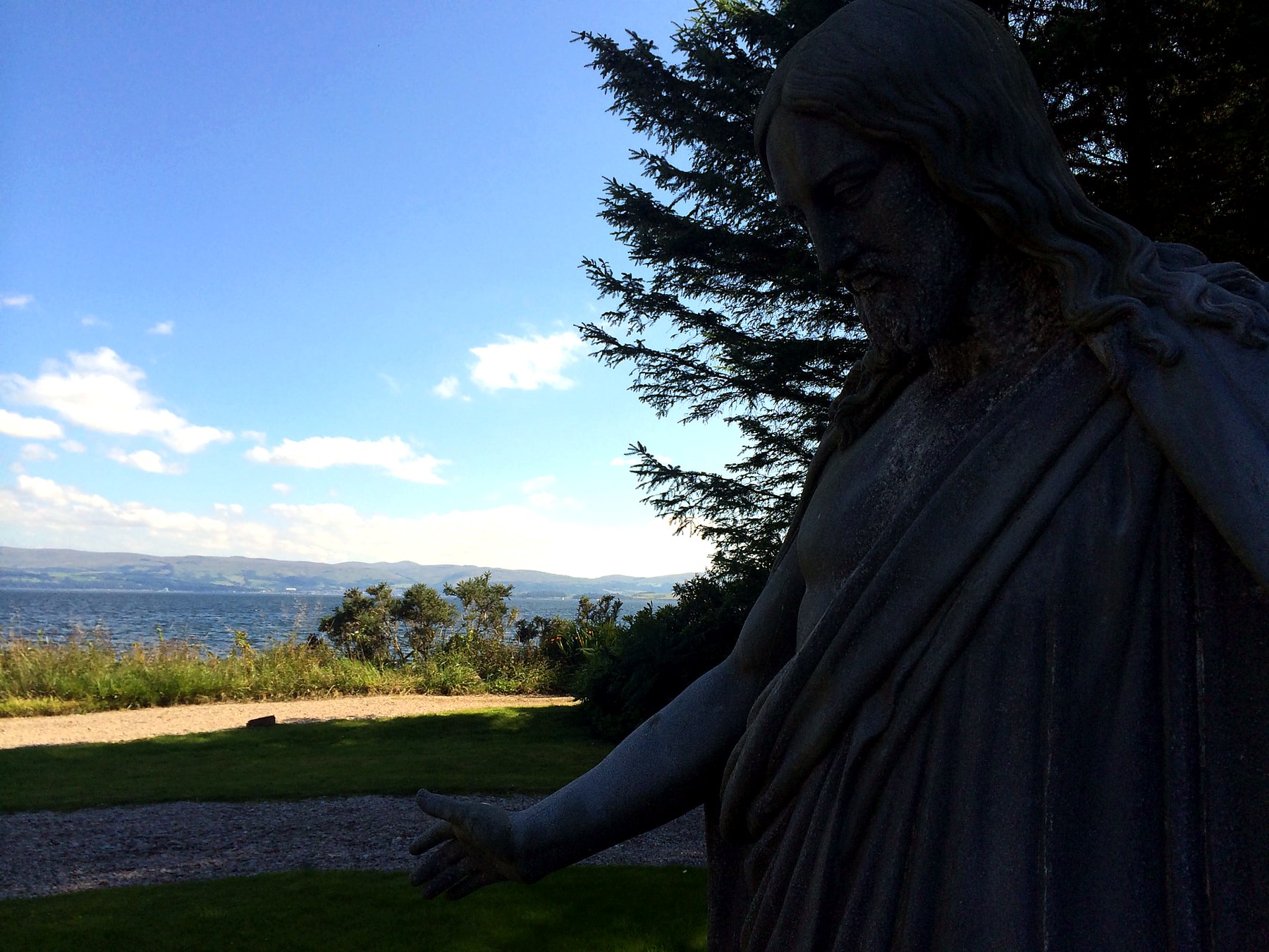 Stone statue of Christ with arms outstretched above the Firth of Clyde at Mount Stuart, Isle of Bute