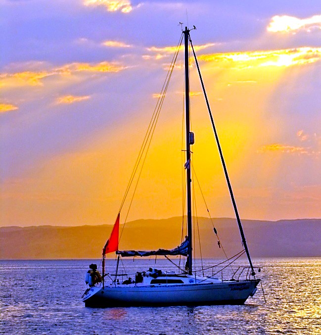 Yacht at anchor in golden sunset light off the Isle of Bute in the Firth of Clyde