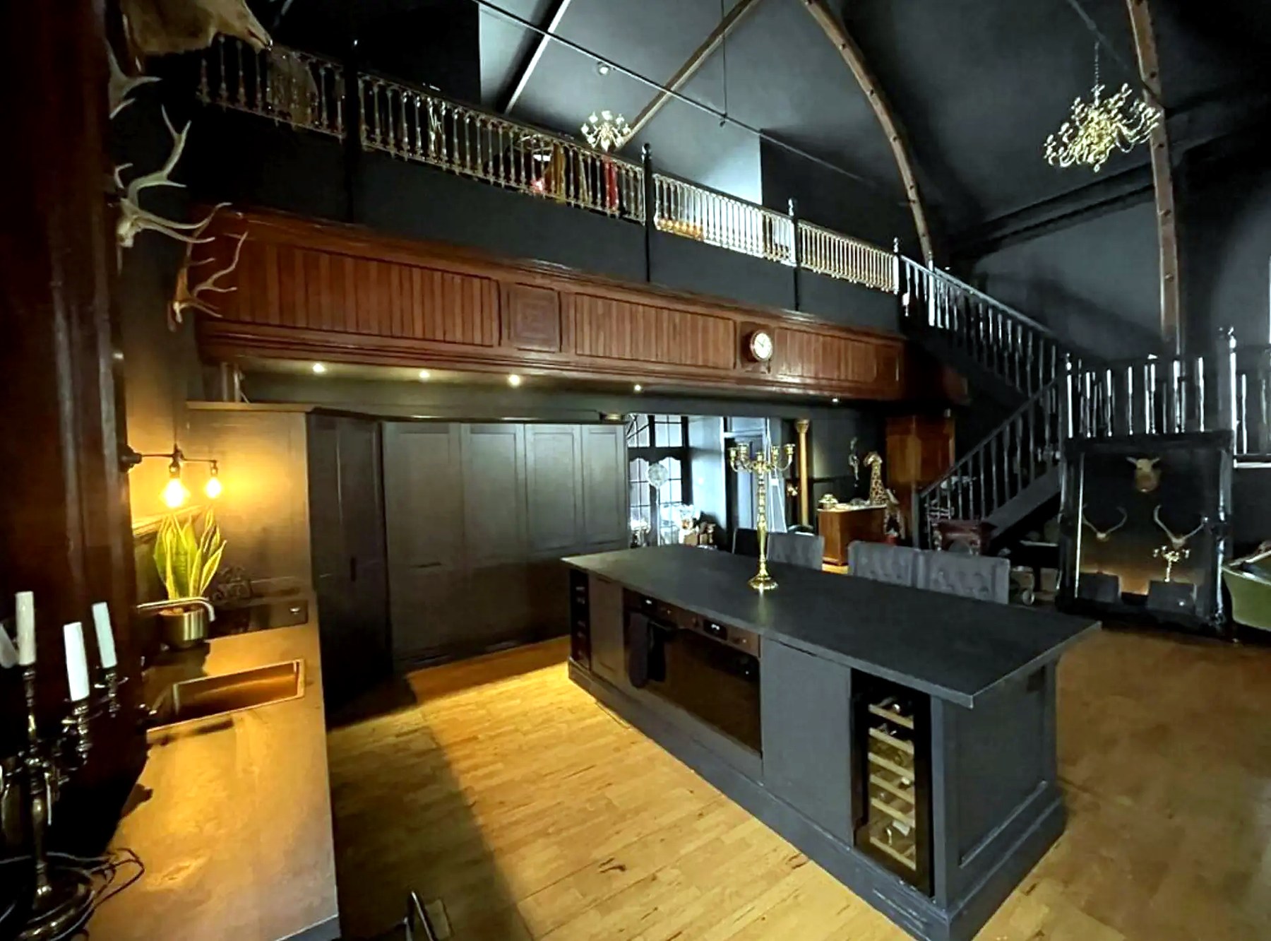 Dark kitchen island beneath the timber mezzanine at The Old Church