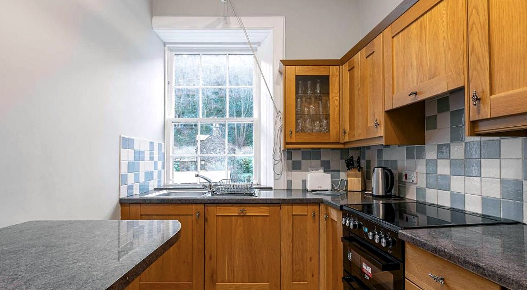 Oak kitchen at Govandale Seaviews with a range cooker and tiled splashback