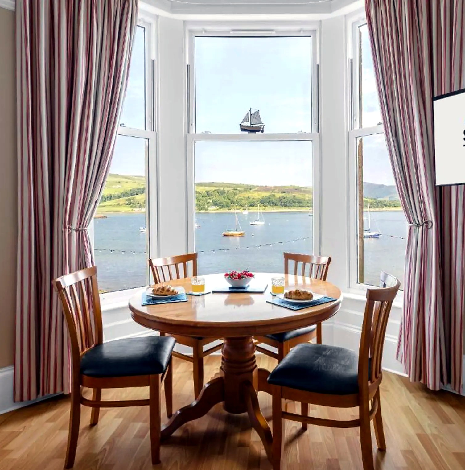Breakfast table in the bay window at Above the Bay overlooking yachts on Kames Bay
