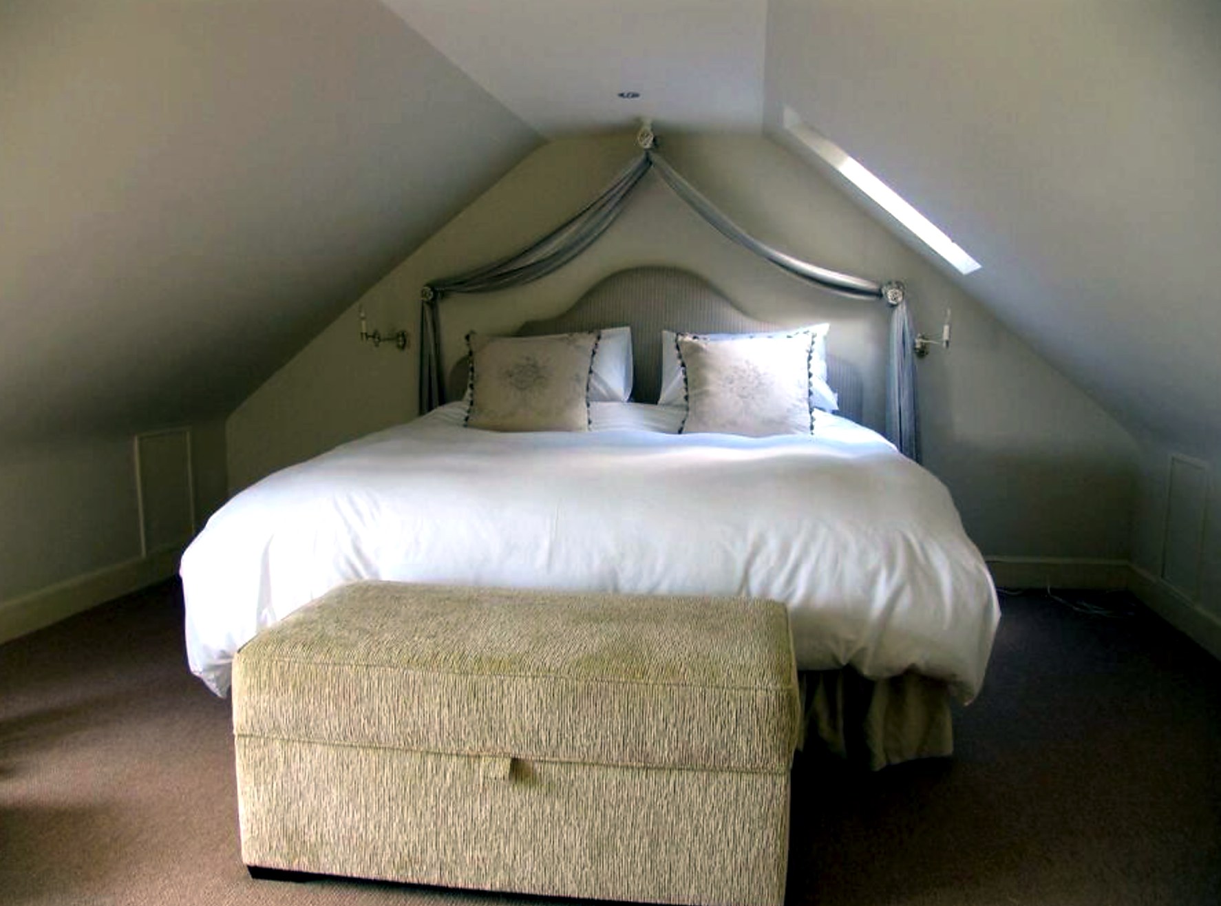 Eaves bedroom at The Old School House with a king bed under a skylight