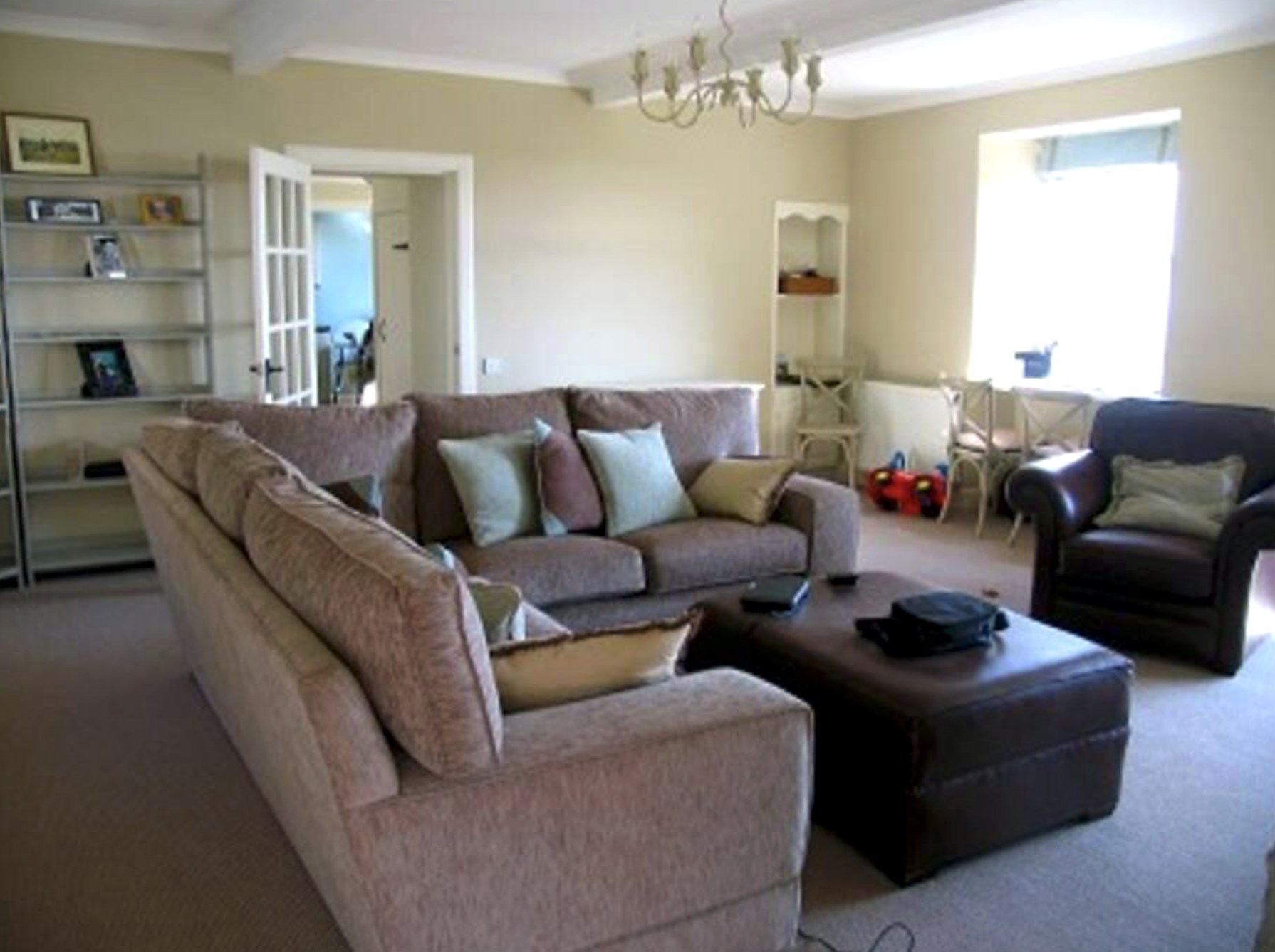 Spacious sitting room at The Old School House with two sofas and a leather ottoman