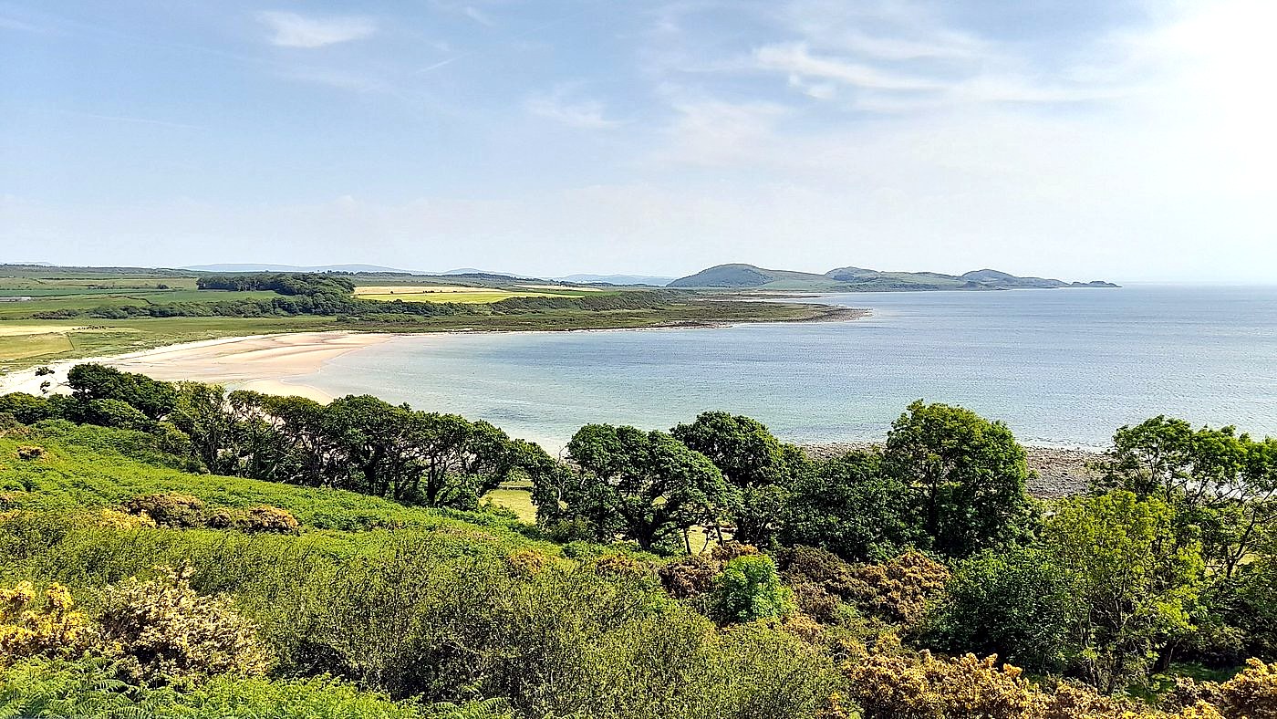 Scalpsie Bay on the Isle of Bute, with its curving sandy beach, gorse-covered hillside and the Arran hills across the water