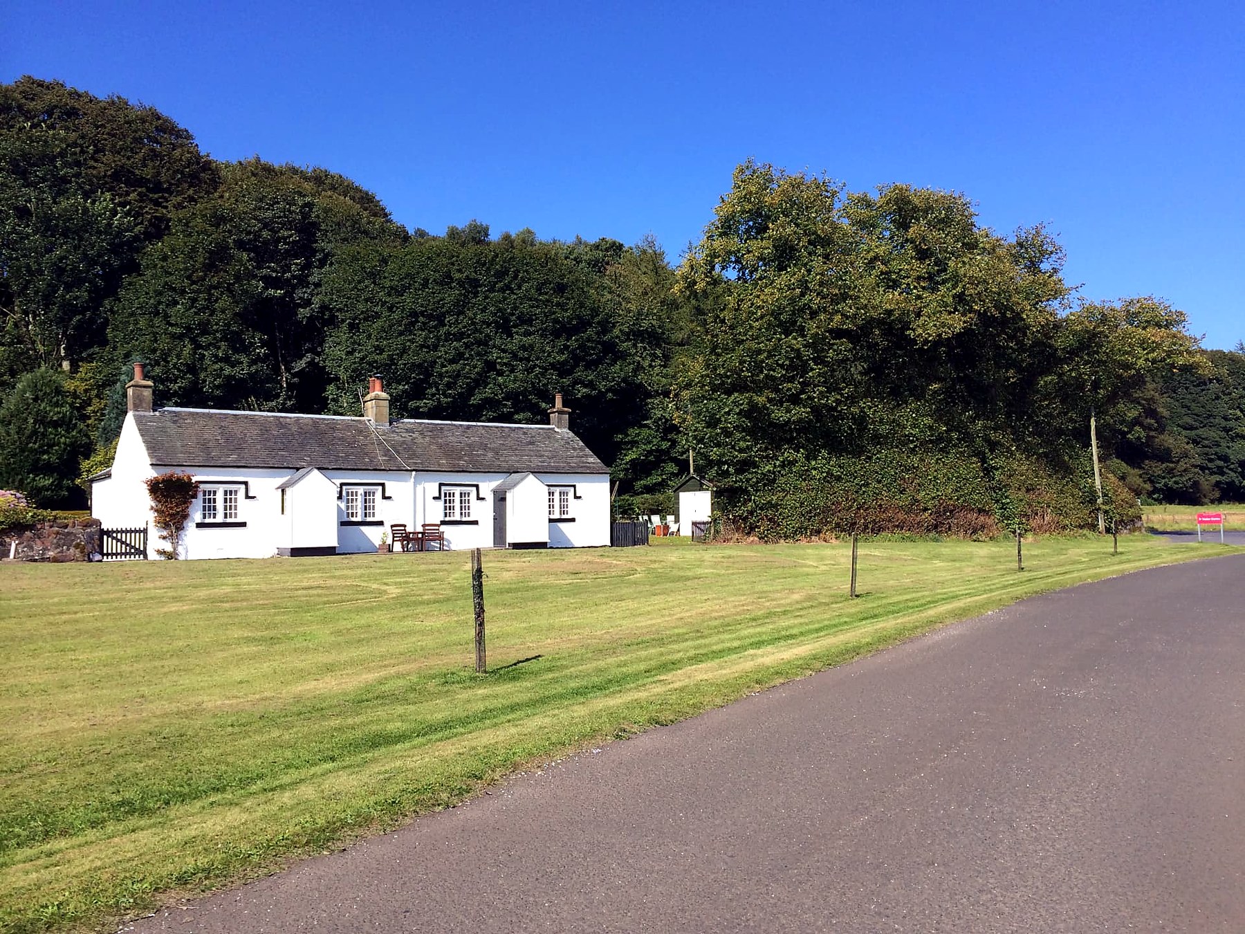 Whitewashed single-storey estate cottage beside the green at Kerrycroy, Isle of Bute