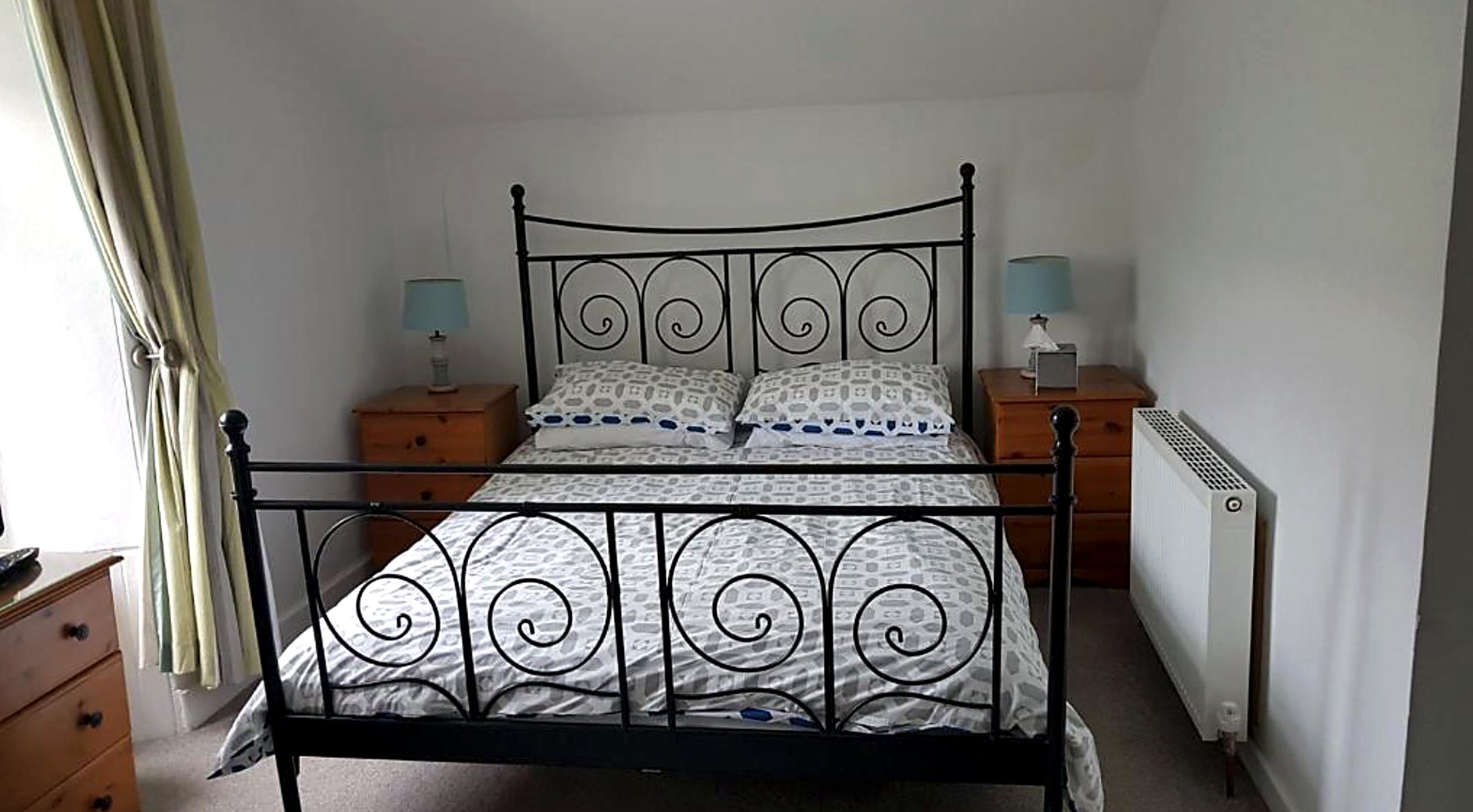 Double bedroom at St Ebba's with a black iron bedstead and pine furniture