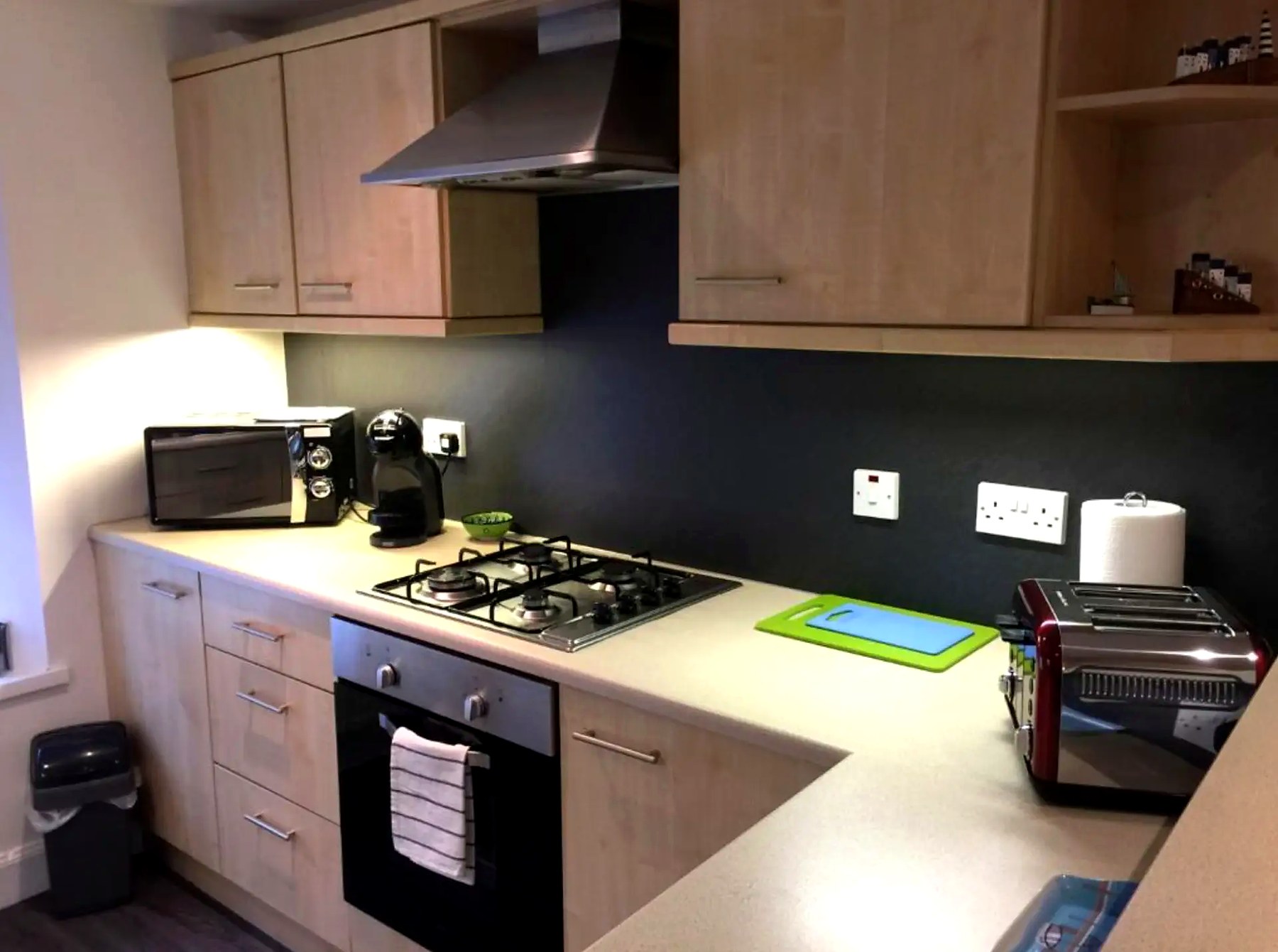 Fitted kitchen at Old Fisherman's Cottage with gas hob, oven and light wood units