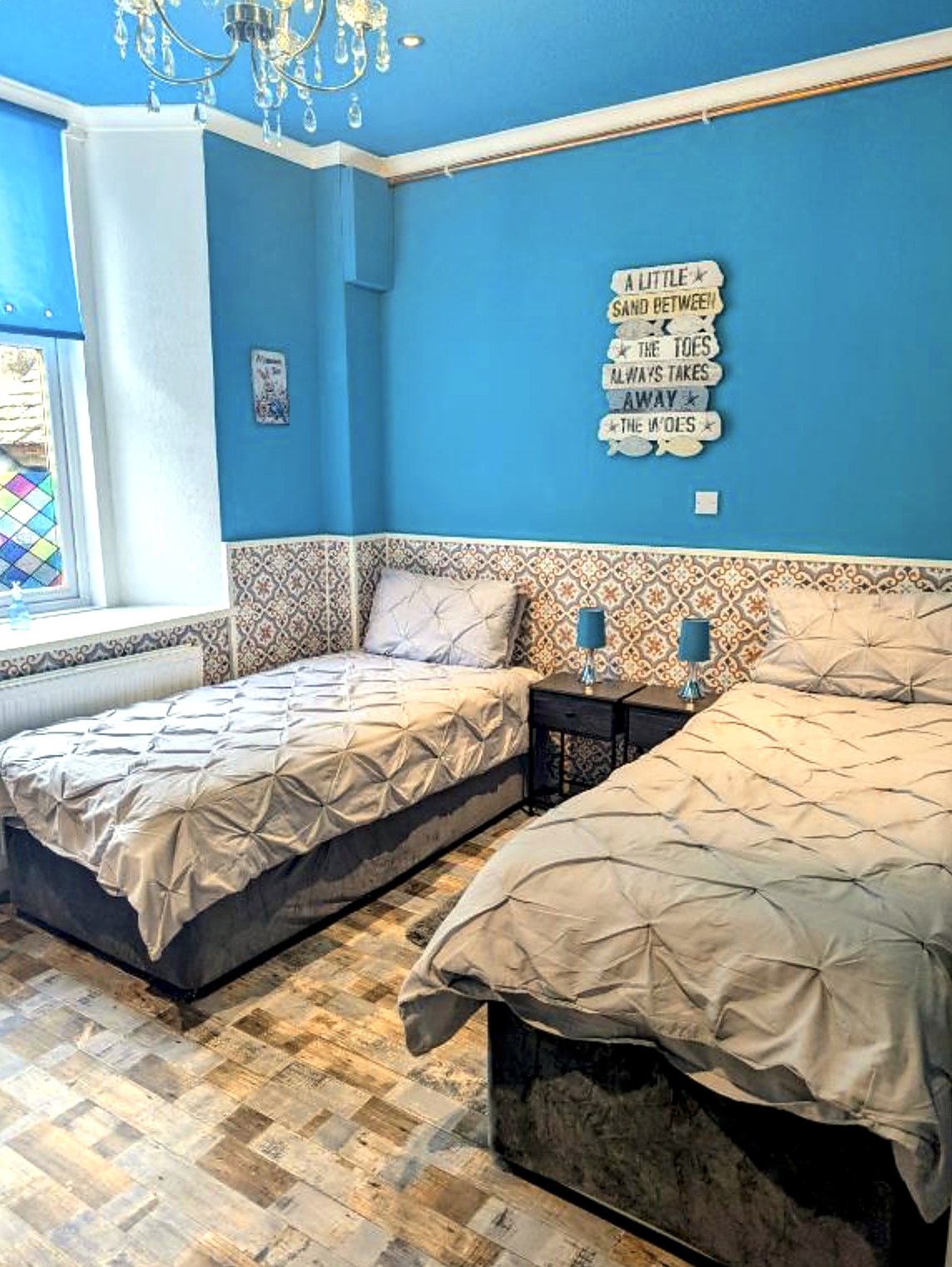 Family room at Commodore Guest House with a double and single bed and coastal wall art