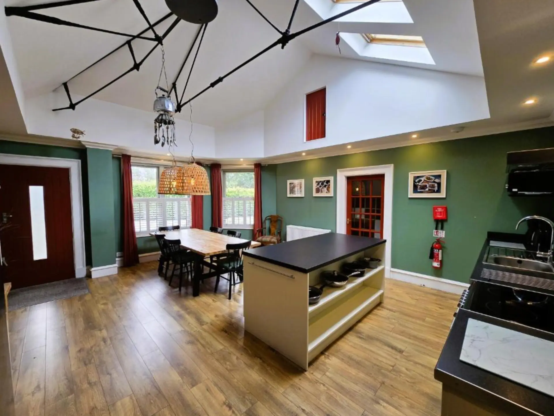 The vaulted open-plan kitchen and dining room at Balmory Stables, with roof lights and a long table