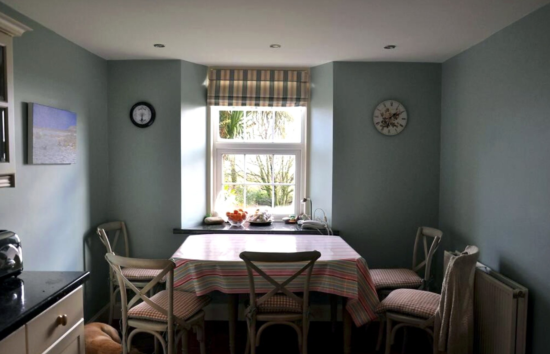 Kitchen dining table for six beside a garden window at The Old School House