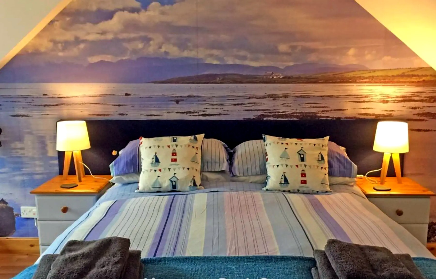 Double bedroom at Old Fisherman's Cottage with sunset sea mural behind the bed