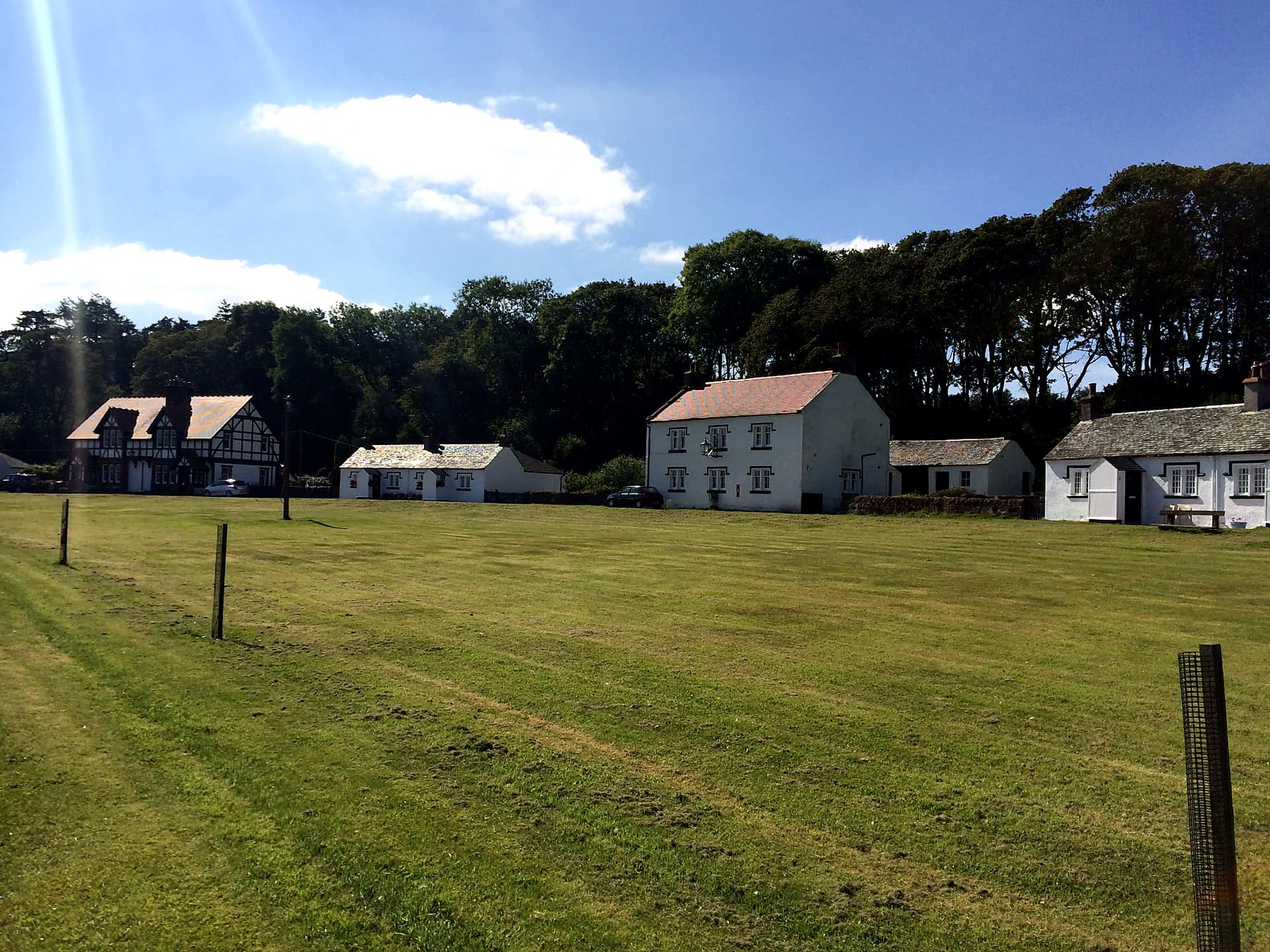 White cottages and a half-timbered house around the village green at Kerrycroy, Isle of Bute