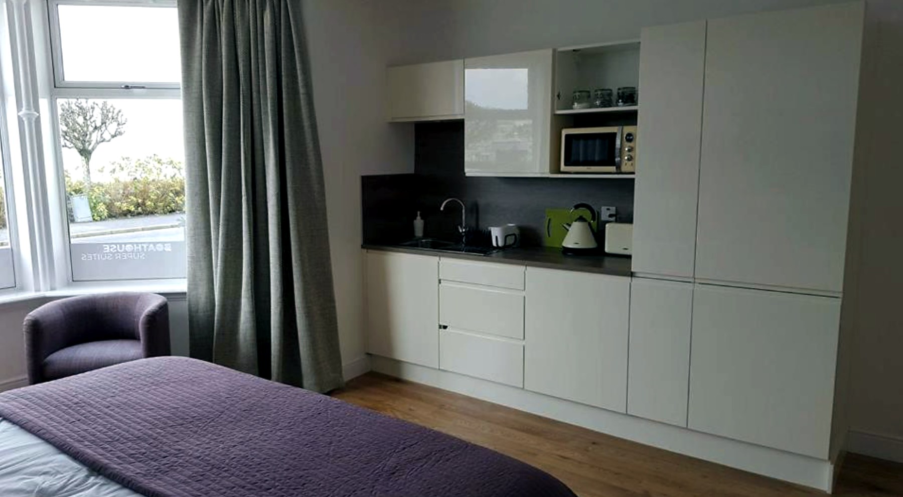 Bright studio space with a fitted kitchen along one wall and a window onto the bay
