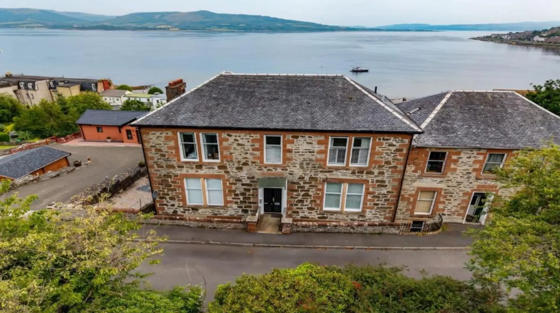 The red sandstone villa housing The Hidden Asset apartment above Rothesay Bay