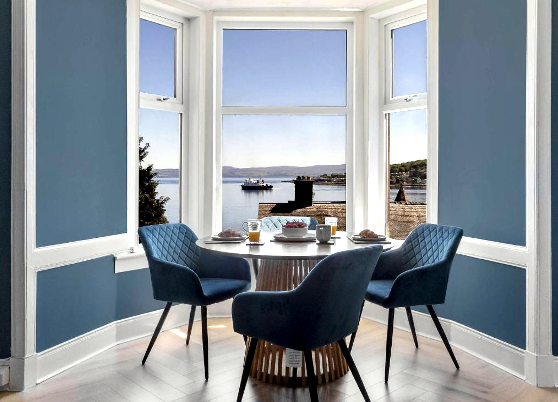 Bay window dining table at The Bayview with the ferry crossing Rothesay Bay