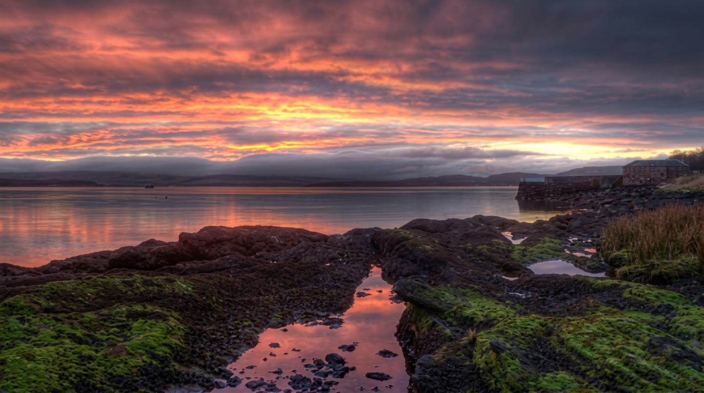 Dawn light over rock pools and the water at Kilchattan Bay