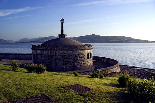 Domed circular stone building on the seafront with the hills of the Firth of Clyde beyond, Isle of Bute
