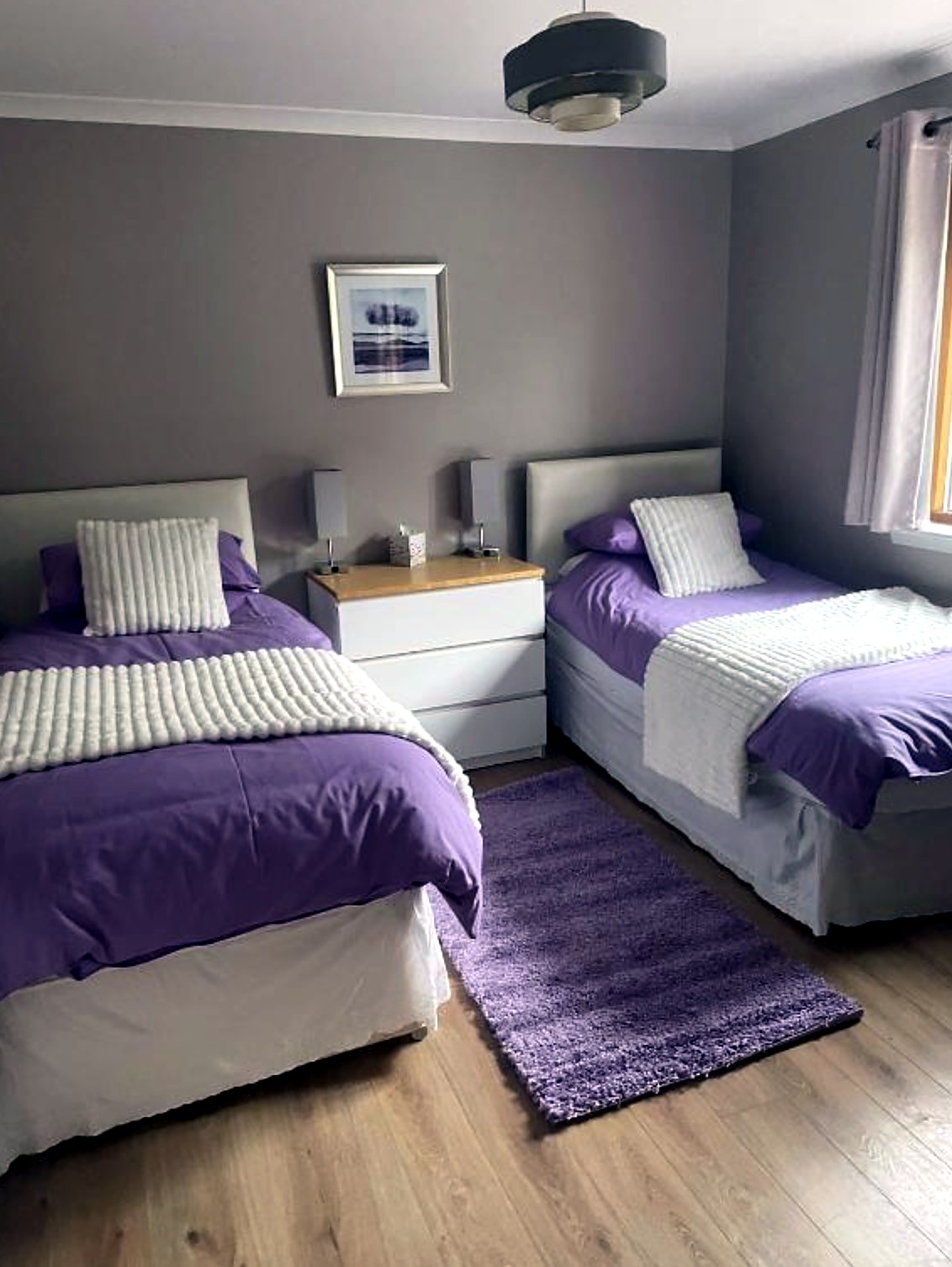 Twin bedroom at Fraoch with purple bedding and matching rug