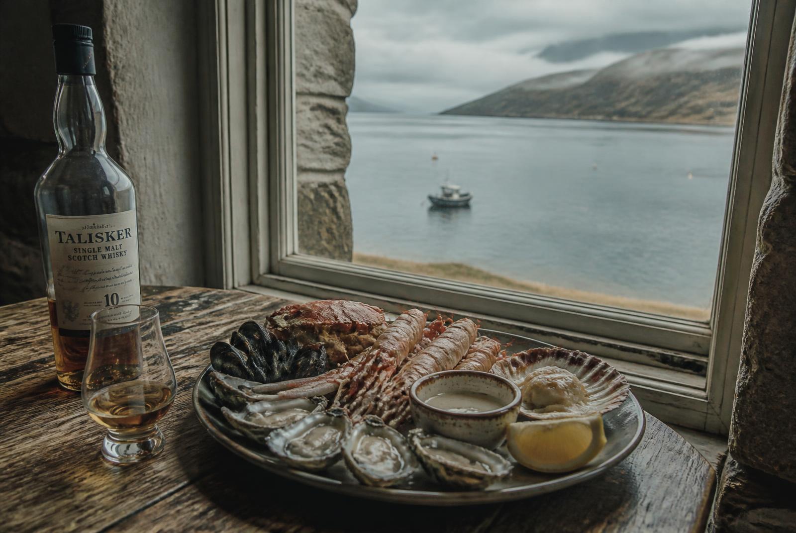 Scottish island seafood platter and a dram beside a window looking out to sea